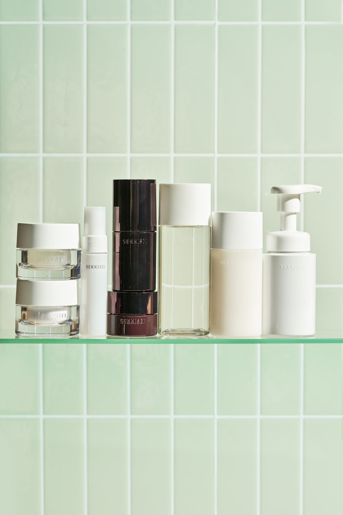 Set of SEKKISEI Clear Wellness products on a green tiled shelf