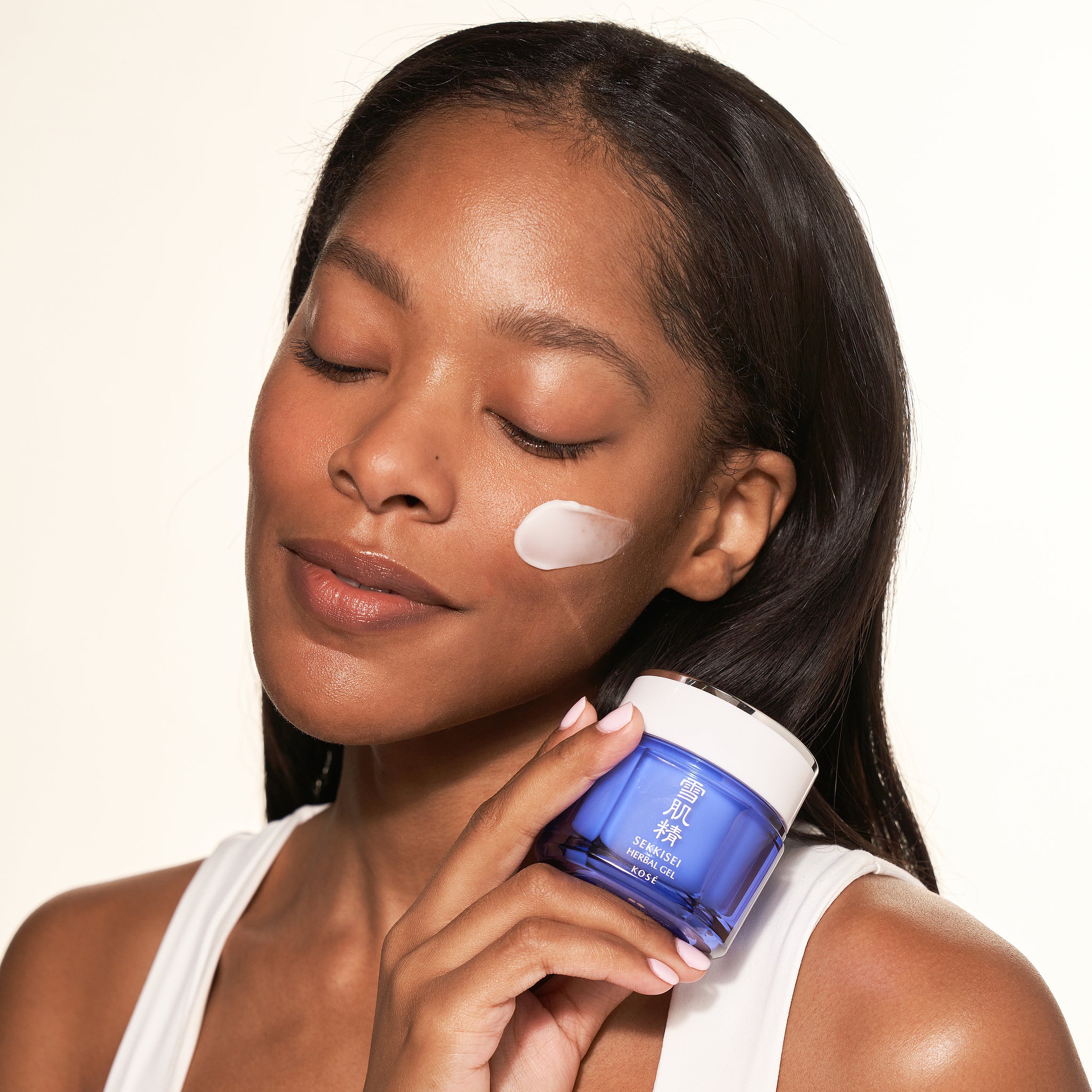 Woman applying SEKKISEI Herbal Gel cream to her face